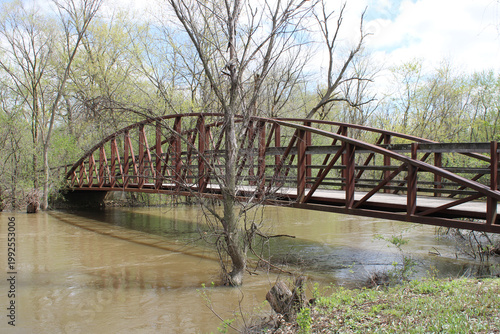 Foto Wood and metal arch footbridge over a muddy Des Plaines River at Captain Daniel