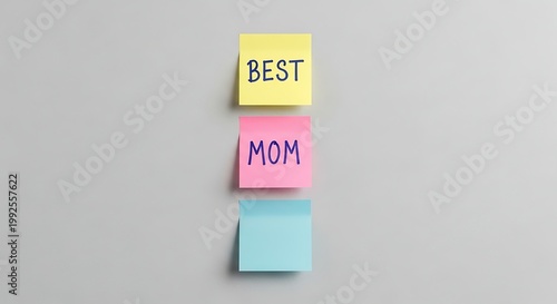 Three colorful sticky notes arranged vertically on a plain grey wall with text best mom.