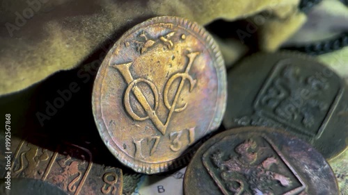 Close up video of an antique VOC 1 duit coin dated 1731, featuring the classic VOC monogram and a fox privy mark.