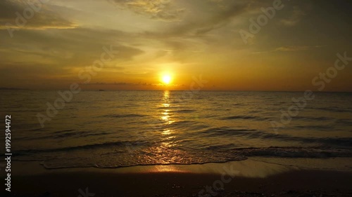 Golden Sunset with Bright Sun Over Tropical Ocean Shore with Glowing Light Trail on Wet Sand