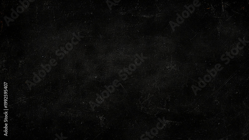 Scratched dark surface with white specks and scratches all over black background texture