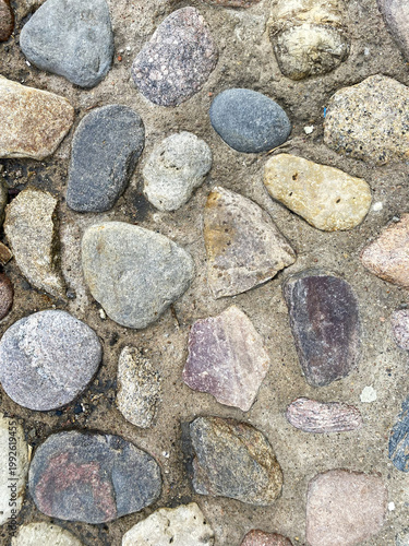 Schilderij op canvas Surface of natural stones laid in a pattern on a pathway during daylight