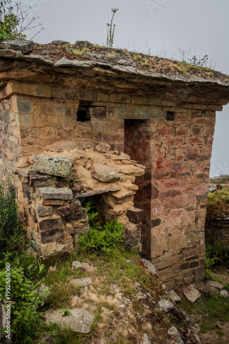 Ancient Stone Hut with Collapsed Entrance in Mountain Ruins