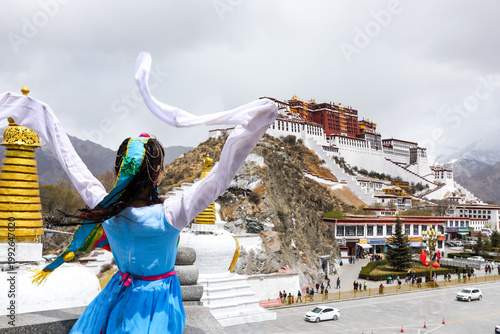 Photos Woman in traditional Tibetan dress facing Potala Palace, Lhasa Tibet