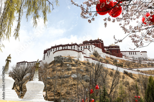 Tablou pe pânză Potala Palace in Lhasa Tibet with spring blossoms and red lanterns