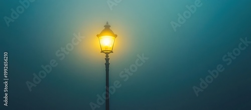 Glowing vintage street lamp in dense, atmospheric fog at night