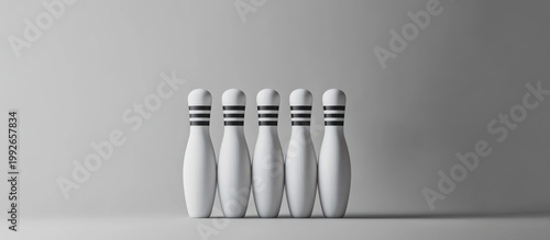 Five White Bowling Pins Standing in a Row on a Neutral Grey Studio Background