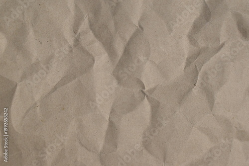 Greyish brown crumpled paper texture background, top view. 
