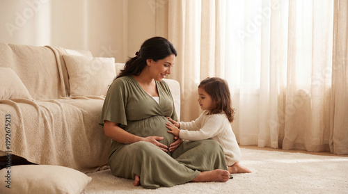 Mother's Day pregnant woman with toddler daughter on floor touching belly expressing sibling curiosity love for lifestyle magazine editorial photography