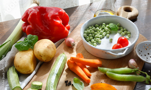 Selection of vibrant farm vegetables and vintage metal utensils on rustic kitchen board. Close-up composition displays fresh seasonal ingredients ready for traditional homemade soup capturing