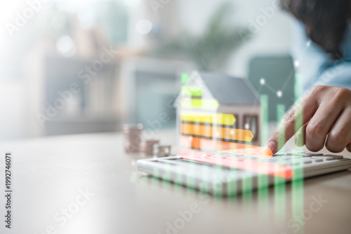 Φωτογραφία Person using calculator with house model and energy efficiency graph, representi