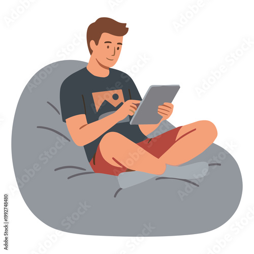 A man sits on a beanbag chair using a tablet indoors leisurely