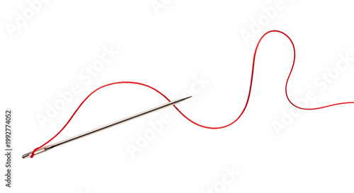 Close up of a sewing needle threaded with red yarn