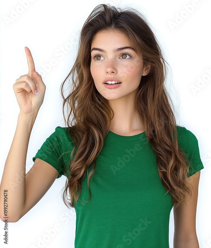 woman with long wavy brown hair wearing a green t-shirt pointing upward with index finger on a white background, confident and instructive gesture suggesting an idea