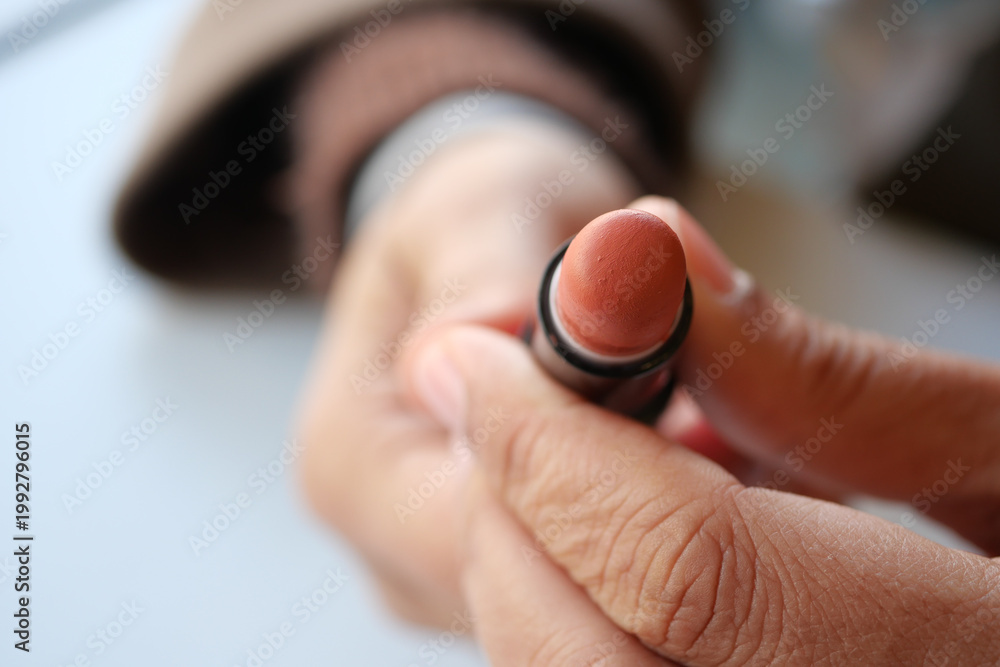 Fototapeta premium Holding a lipstick tube in a close-up moment