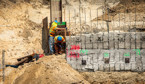 Construction workers on a project with retaining walls and rebar