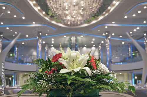 Futuristic modern Art Deco interior design style furniture, carpets and paneling onboard luxury cruiseship liner cruise ship main dining room restaurant with columns and chrome chandelier