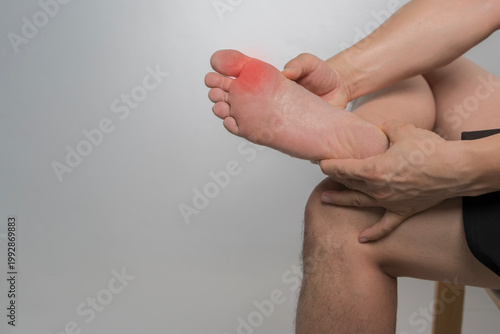 Closeup of painful foot sole with red inflammation highlight on gray background