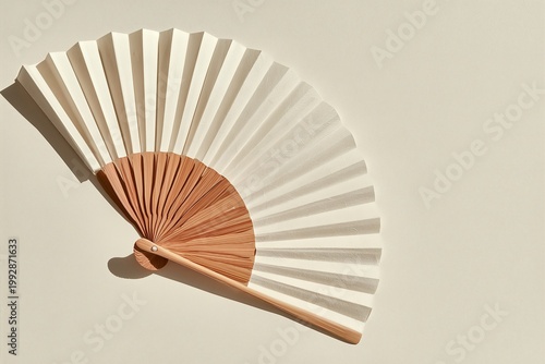 Minimalist traditional Korean folding fan with bamboo ribs and white paper on neutral background with shadows
