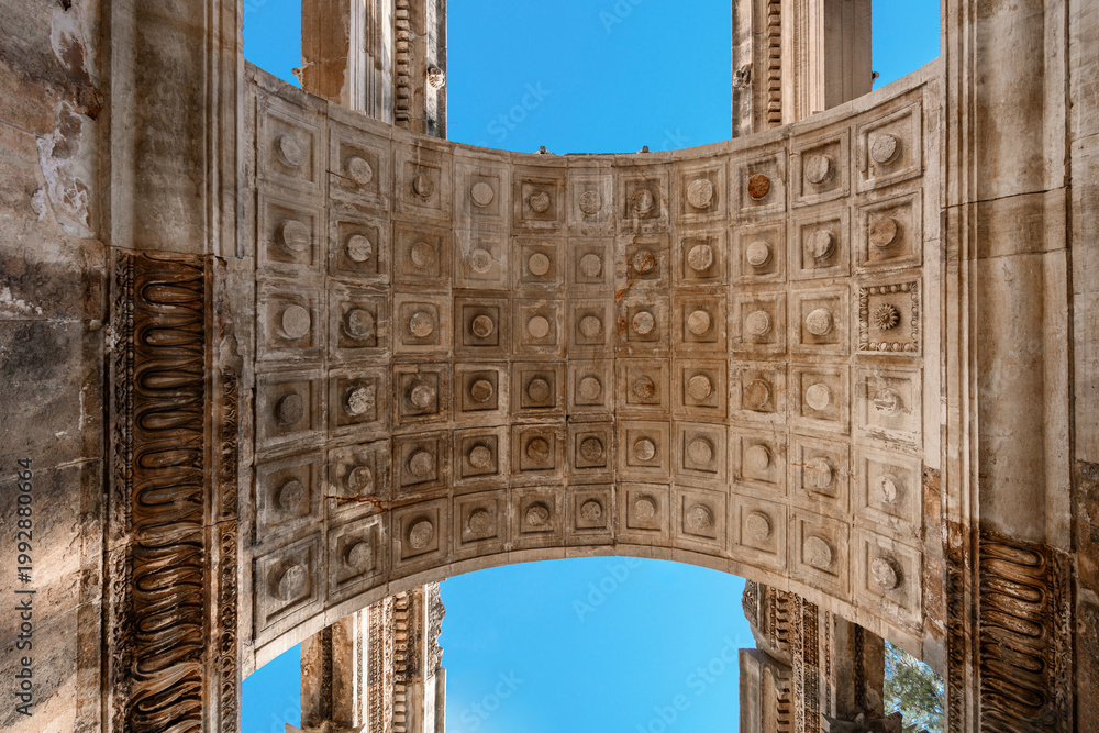 Fototapeta premium The symmetrical coffered ceiling pattern of the ancient Roman arch structure of Hadrian's Gate in Antalya