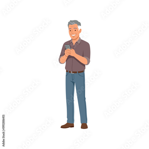 A man is standing and smiling while looking at his phone.