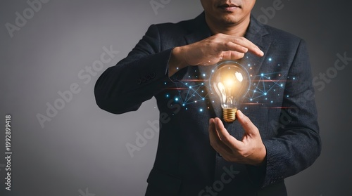 Businessman in a suit holding a glowing lightbulb with a circuit board background
