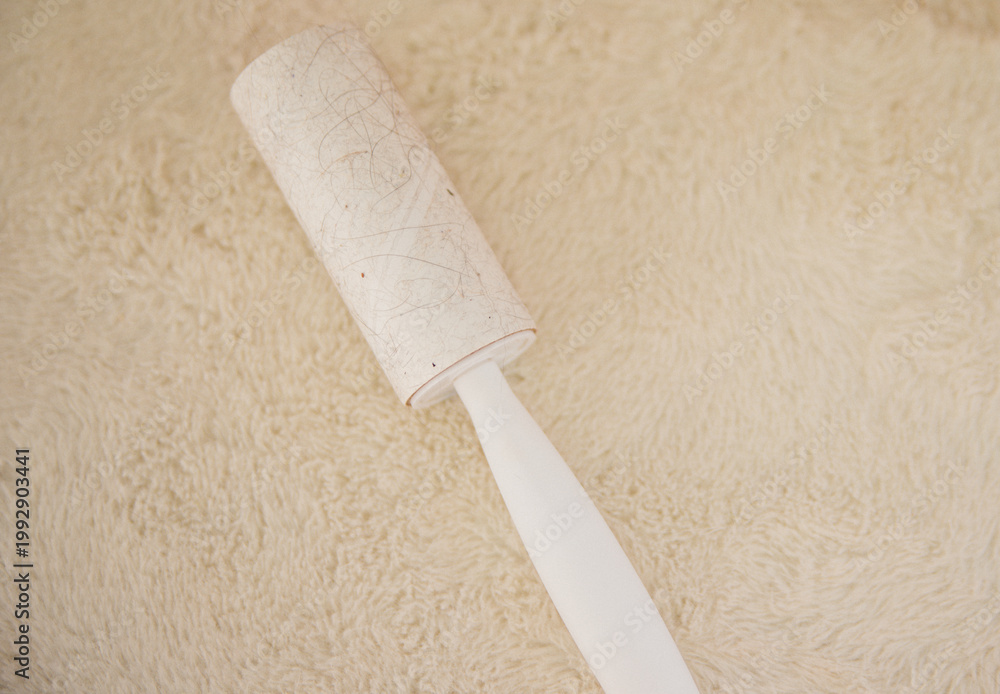 Obraz premium White upholstered furniture surface with sticky cushion. Cleaning of upholstered furniture from dust, wool and hair.