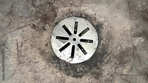 Basement floor drain close up with concrete surface showing residential plumbing and home maintenance detail