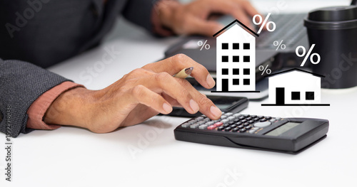 business man with calculator and calculate interest rate of condo and home, financial mortgage loan calculation, property tax, and investment