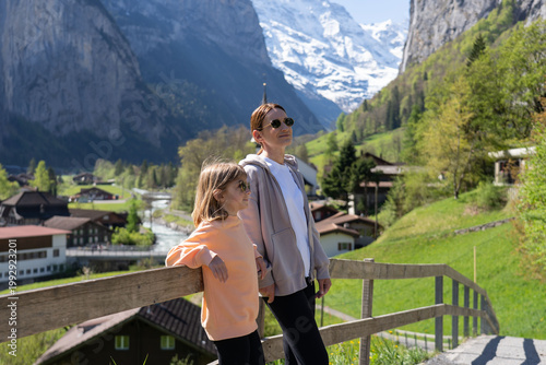 Traveling young woman with child visiting beautiful village in Lauterbrunnen. 