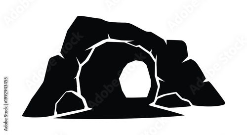 A black silhouette of a cave entrance within a rocky hillside