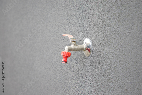 Water faucet on the grey wall, closeup of photo