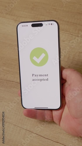 Vertical Screen: A man holds a smartphone displaying a payment accepted message. The action shows the process of making a purchase using mobile payment technology.