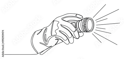 Hand holding a powerful flashlight illuminating the darkness with strong light rays for safety or exploration