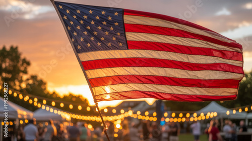 American flag waves proudly over a festive outdoor gathering with string lights during a beautiful sunset
