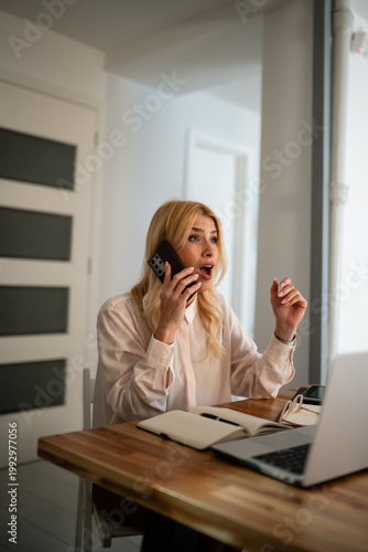 Slika na platnu Woman receiving shocking news on phone while working