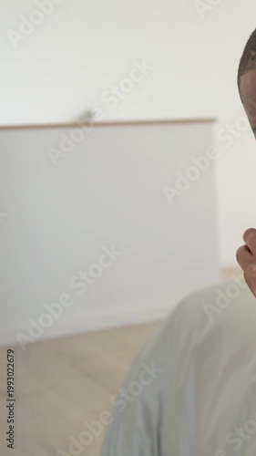 Man sitting bed with clasped hands, camera panning right revealing empty bedroom for mental health