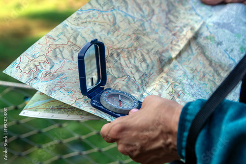 Tableau sur toile Senior hand holding compass and map navigating outdoor adventure