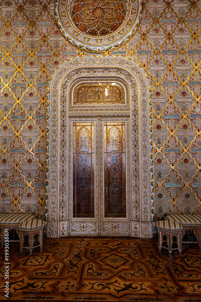 Naklejka premium Ornate Arab Room inside Palacio da Bolsa in Porto featuring intricate decorative ceiling carved arches columns and geometric wooden floor. Famous interior and architectural masterpiece in Portugal.