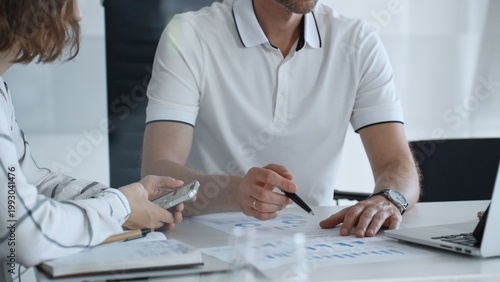 Foto Professional team analyzing financial charts, working together in sleek workspac