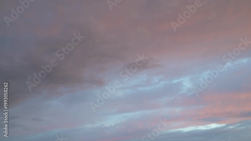 Time-lapse view of dramatic clouds with shifting light effects in the sky.
