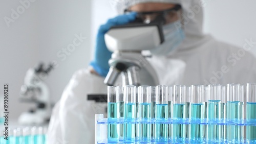 Cuadro en lienzo A medical virologist in protective gear and blue gloves examines viral samples u