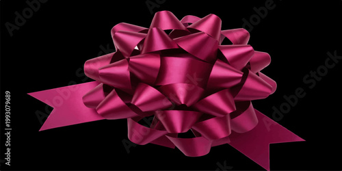 Festive red shiny ribbon bow isolated on a black background for Christmas holiday gift wrapping and anniversary celebration decoration