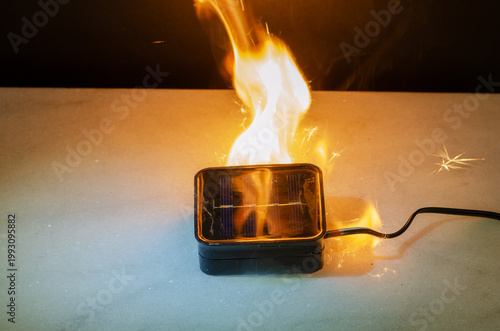 Fotografi Solar light device burning with strong flame and sparks as danger and fire conce