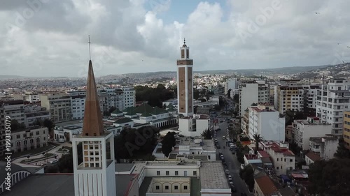 Cinematic drone shot showcasing a church and mosque standing together in Tangier, Morocco, as a powerful symbol of interfaith harmony and peaceful coexistence.