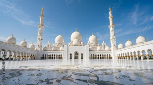 Grand White Mosque With Golden Accents Under A Clear Blue Sky Reflecting On Wet Marble Courtyard Sunlight Illuminating Architectural Details