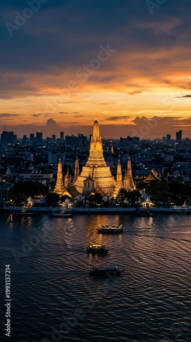 Iconic Wat Arun Temple Illuminated At Dusk Over Chao Phraya River With Bangkok City Skyline In The Background And Fiery Sunset Clouds Above