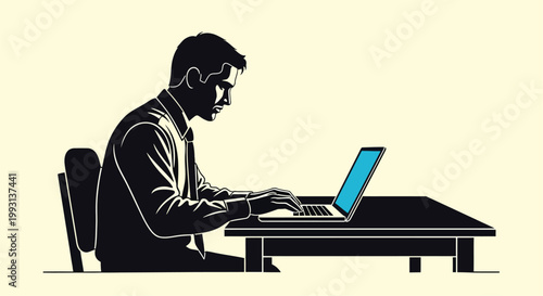 A man in a suit focused on working on a laptop at a desk