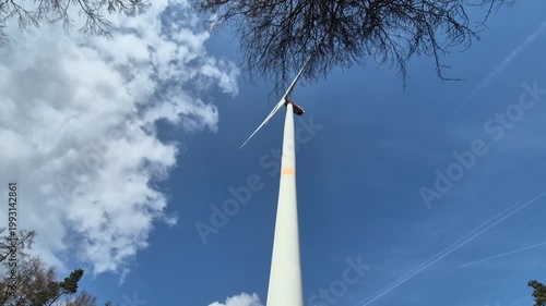 Wind turbine against blue sky.