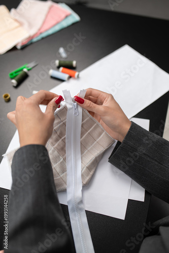 Female fashion designer working with fabric and colorful threads